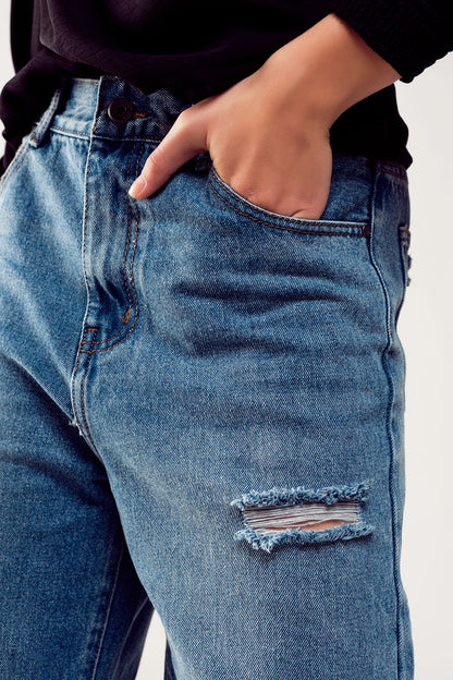 Distressed straight leg jean in medium denim