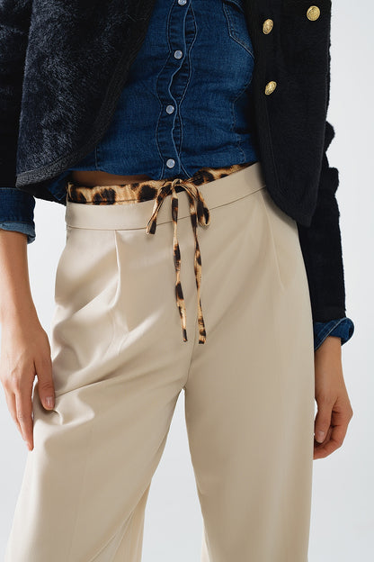 Long beige pleated trousers with leopard detail at the waist