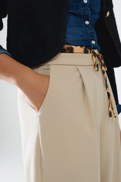 Long beige pleated trousers with leopard detail at the waist