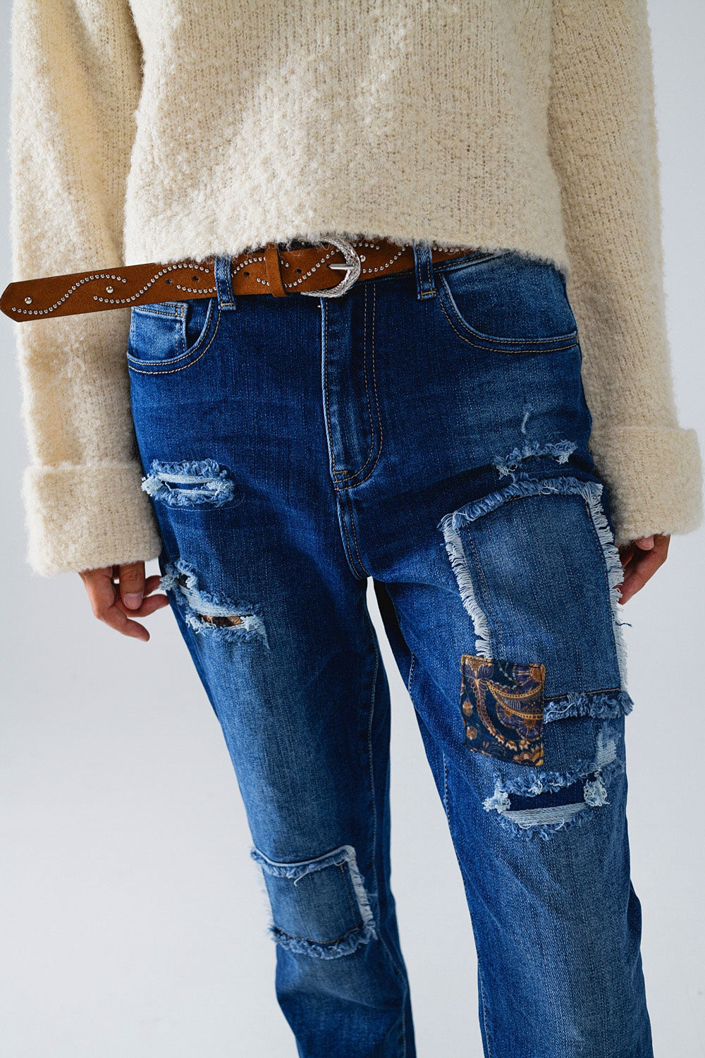 Loose blue jeans with subtle ripped design and patches