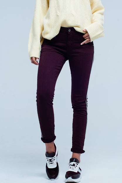 Maroon skinny jeans with metal side stripe